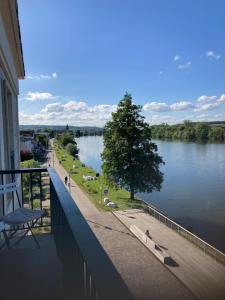 uma varanda de um edifício com vista para um rio em Au fil de la Seine em Vernon