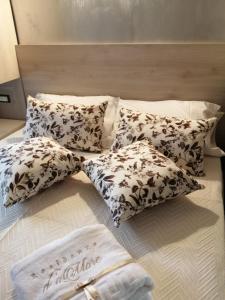 a bed with four pillows on top of it at Ke Rooms in Campomarino