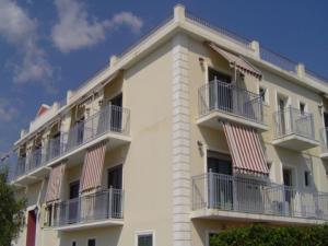 ein weißes Gebäude mit Balkon auf der Seite in der Unterkunft Hotel Kourkoumelata in Argostoli