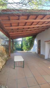 un patio con un banco bajo un techo de madera en Estombar Novo, en Estômbar
