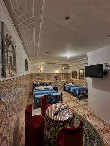 a hotel room with two beds and a table and chairs at Dar Tanger Medina in Tangier