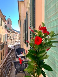 una pianta con rose rosse seduta su un balcone di Historic building by the sea a Finale Ligure