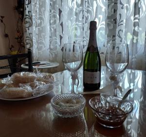 - une bouteille de vin assise sur une table avec 2 verres à vin dans l'établissement Glyfada Villas, à Paralio Astros
