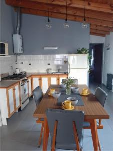 a kitchen with a wooden table and chairs in a kitchen at La huerta in Ushuaia