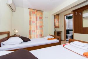 a bedroom with two beds and a window at Villa Jadran in Trogir