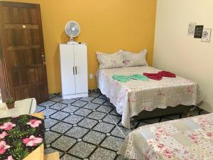 a room with two beds and a fan at Suite Raio de Sol in Vale do Capao