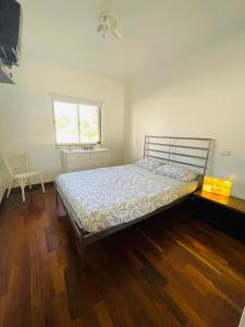 1 dormitorio con 1 cama, suelo de madera y ventana en Apartamento Praia do Vau, en Alvor