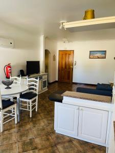 a living room with a kitchen and a table and chairs at Apartamento Praia do Vau in Alvor