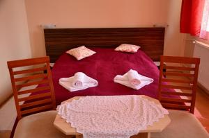 a bedroom with a bed with a table and towels at Hotel Priehrada in Dedinky