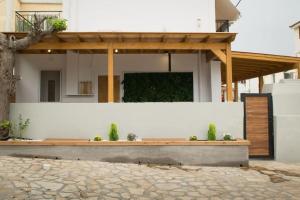Alfa house w/ view & barbeque in Pythagorion في بيثاغوريو: منزل به جدار أبيض وبه نباتات خزفية