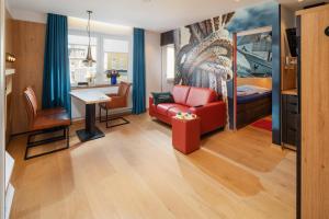 ein Wohnzimmer mit einem roten Sofa und einem Tisch in der Unterkunft neyland apartments Norderney in Norderney