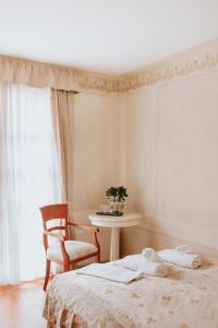 sypialnia z łóżkiem, stołem i oknem w obiekcie Villa Toscana Warszawa w Warszawie
