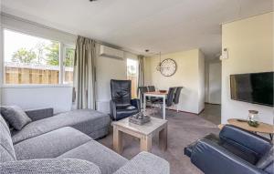 ein Wohnzimmer mit Sofas, Tisch und Fernseher in der Unterkunft Amazing Stacaravan In Tzummarum in Tzummarum