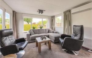 ein Wohnzimmer mit Sofa, Stühlen und einem Tisch in der Unterkunft Amazing Stacaravan In Tzummarum in Tzummarum