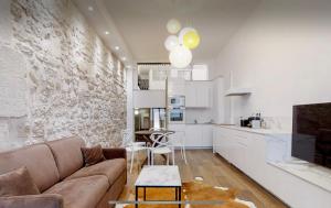 een woonkamer met een bank en een keuken bij Loft HeartofParis, Marais,Chatelet, Beaubourg CLIM in Parijs
