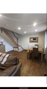 a living room with a table and a staircase at Sunset cottage in Burry Port