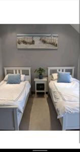 two beds sitting next to each other in a room at Sunset cottage in Burry Port