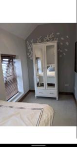 a bedroom with a mirror and a bed in it at Sunset cottage in Burry Port