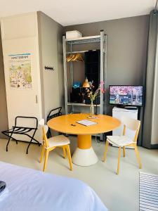 a room with a table and chairs and a bed at Private studio, patio garden and free car parking in Amsterdam