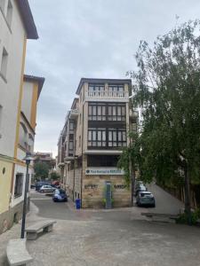 un edificio alto con due panchine davanti di Apartamento Los Arcos a Llanes