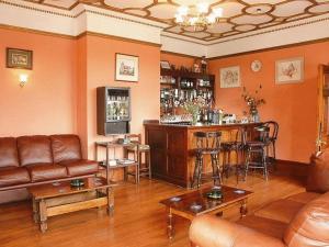 a living room with a bar with a couch and chairs at The Grange Hotel in King's Lynn