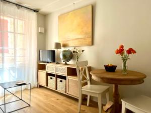 a living room with a table and a television at Les Petits Volets 3 appartements au choix in Antibes