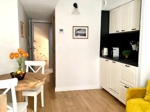 a kitchen with a table and a yellow couch at Les Petits Volets 3 appartements au choix in Antibes