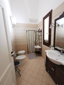 bagno con lavandino, servizi igienici e specchio di ARCO ANTICO a Nardò