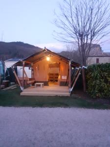 una casa con un porche y un banco frente a ella en Camping les Lavandes, Castellane en Castellane