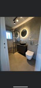 a bathroom with a toilet and a sink at luksus spahus i skagen in Skagen