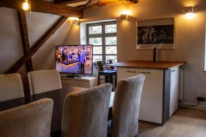 a dining room with a television and a table and chairs at Schloss Mühlen in Horb am Neckar