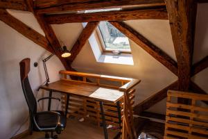 Zimmer im Dachgeschoss mit einem Schreibtisch und einem Fenster in der Unterkunft Schloss Mühlen in Horb am Neckar