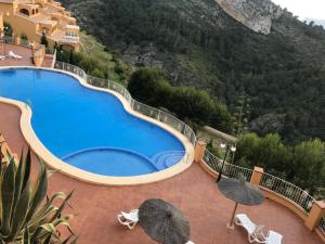 una gran piscina con sombrillas en un patio en Apartmán Marcella, Cumbre del Sol, en Cumbre del Sol