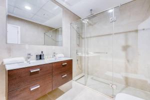 W łazience znajduje się szklana kabina prysznicowa i umywalka. w obiekcie Large Marina 3 bed pool gym and beach club access w Dubaju