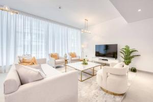 salon z białymi meblami i telewizorem z płaskim ekranem w obiekcie Large Marina 3 bed pool gym and beach club access w Dubaju