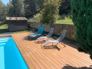 a deck with two chairs and a swimming pool at Le Grenadier in Saint-Mitre-les-Remparts