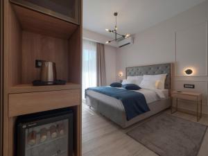 1 dormitorio con cama, TV y chimenea en Hotel Idila Budva en Budva