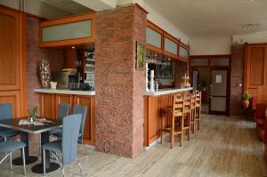 un restaurante con una pared de ladrillo, mesas y sillas en Hotel Priehrada, en Dedinky