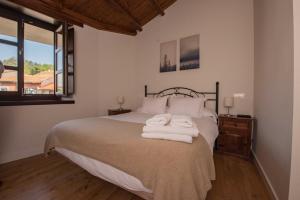 a bedroom with a bed with towels on it at Apartamentos Rurales Playas De Niembro in Llanes