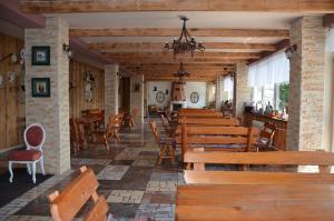 a restaurant with wooden benches and tables and chairs at Hotel Priehrada in Dedinky