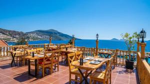 a restaurant with tables and chairs and the ocean at Old Trading House in Kalkan