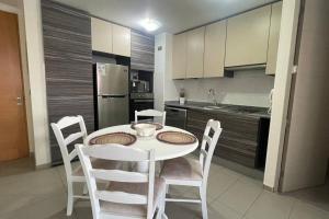 a kitchen with a white table and chairs in a room at Hermoso departamento en la Península en Iquique in Iquique