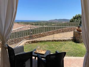 un patio con tavolo, sedie e vista di VISTA MARE a Budoni