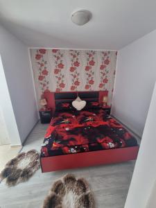a bedroom with a bed with a red comforter at Apartament Alina in Saturn