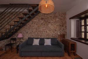 a living room with a couch and a brick wall at Apartamentos Rurales Playas De Niembro in Llanes