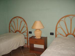 una camera da letto con due letti e una lampada su un tavolo di VISTA MARE a Budoni