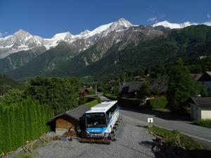 um autocarro estacionado na berma de uma estrada com montanhas em Chalet La Barme Les Houches Vallée de Chamonix em Les Houches