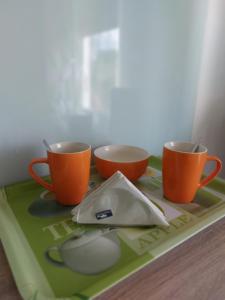 three cups and a computer mouse sitting on a tray at Wohnung Mona in Herford