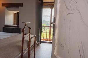 a door leading to a bedroom with a balcony at Apartamentos Rurales Playas De Niembro in Llanes