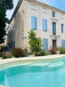 una casa con una gran piscina frente a un edificio en Maison du Midi, 2 Gîtes de charme en Ginestas